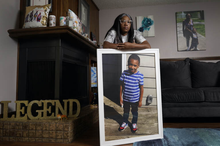 Charron Powell stands with a photo of her son, LeGend Talieferro, at her home in Raytown, Mo. on Sunday, Oct. 3, 2021. LeGend was 4 years old when he was fatally shot June 29, 2020 while he was sleeping in an apartment staying with his father. 